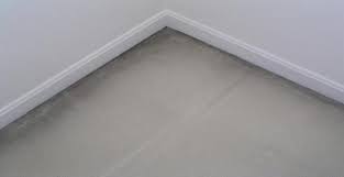 Applying caulking along the base of a wall before carpet installation to prevent black lines
