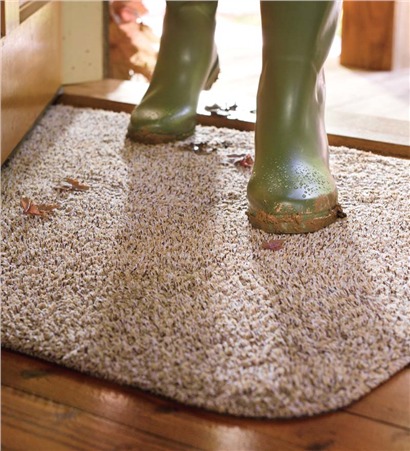 Snow and winter debris being tracked onto a carpet from boots, illustrating the need for winter carpet protection