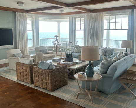 Bright coastal living room with clean area rug overlooking the ocean.